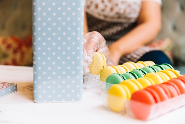 Foto gratuita dependienta preparando caja de macarons