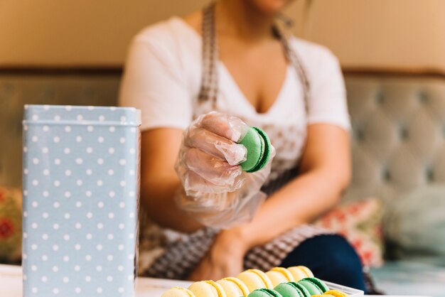 Dependienta preparando caja de macarons