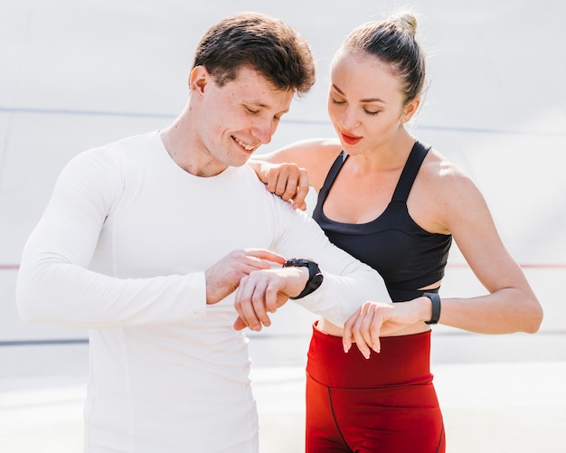 Deporte pareja revisando sus relojes