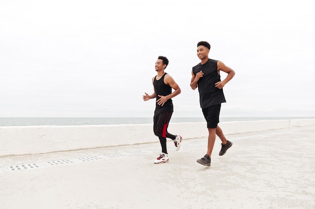 Deportes africanos hombres amigos corriendo al aire libre