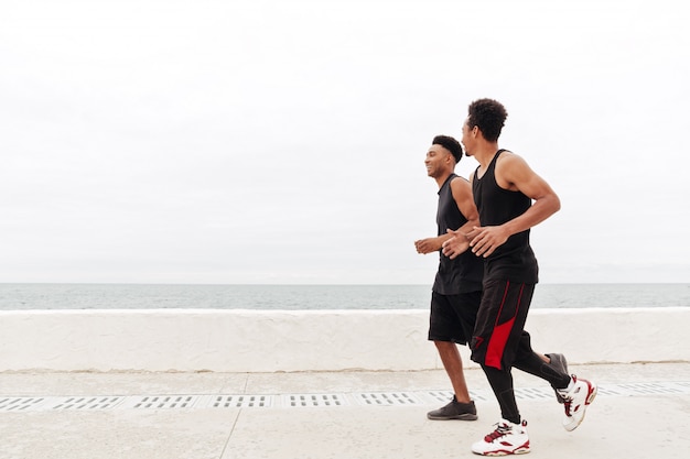 Deportes africanos hombres amigos corriendo al aire libre