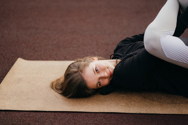 Deportes y fitness fuera del gimnasio. Colocar joven mujer en ropa deportiva entrena al aire libre en el patio de recreo.