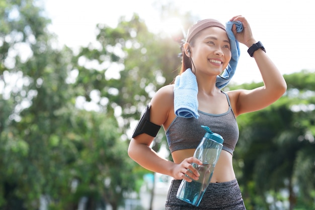 Deportista alegre con botella y toalla