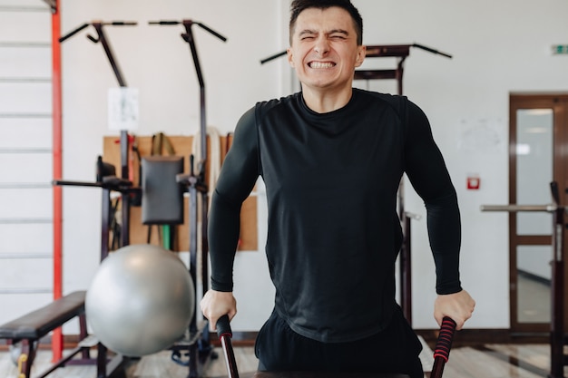 El deportista aprieta las barras, hace ejercicios con los músculos pectorales. estilo de vida saludable.