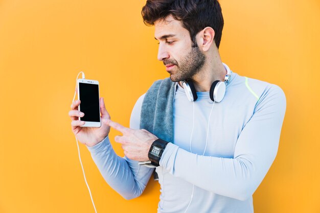 Deportista apuntando al teléfono inteligente