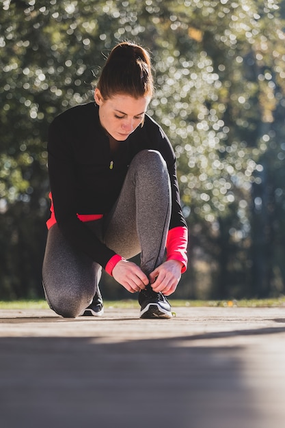 Foto gratuita deportista atándose los cordones