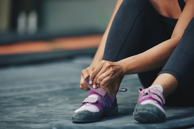Foto gratuito deportista de cultivos poniéndose zapatillas