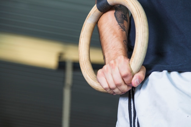 Foto gratuita deportista de cultivos usando anillos gimnásticos