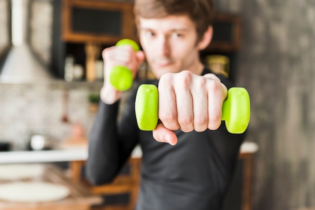 Foto gratuita deportista enfocado en entrenamiento con pesas pequeñas