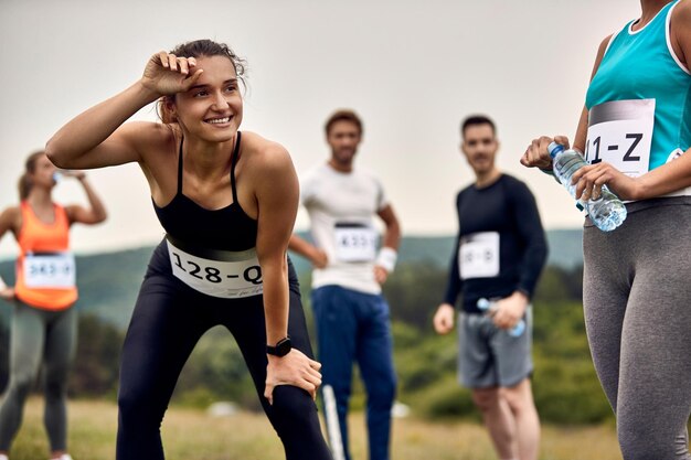 Deportista feliz sintiéndose exhausta después de correr un maratón en la naturaleza