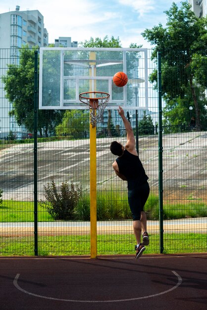 Deportista marcando un gol en el aro de baloncesto