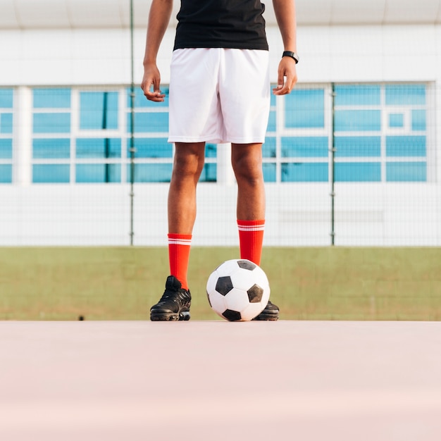 Foto gratuita deportista de pie con el fútbol y preparándose para el juego en el estadio