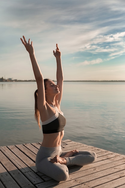 Deportista en la playa hacer ejercicios de meditación.