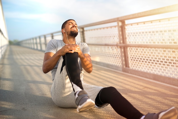 Foto gratuita deportista con problema de lesión de rodilla durante el entrenamiento de carrera