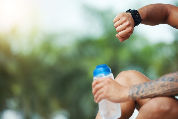 Deportista que controla el reloj inteligente al aire libre