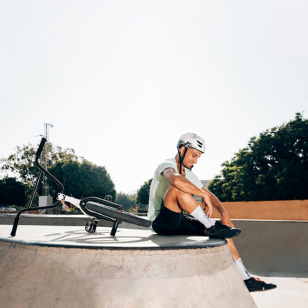 Foto gratuita deportista sentado en skatepark tiro largo