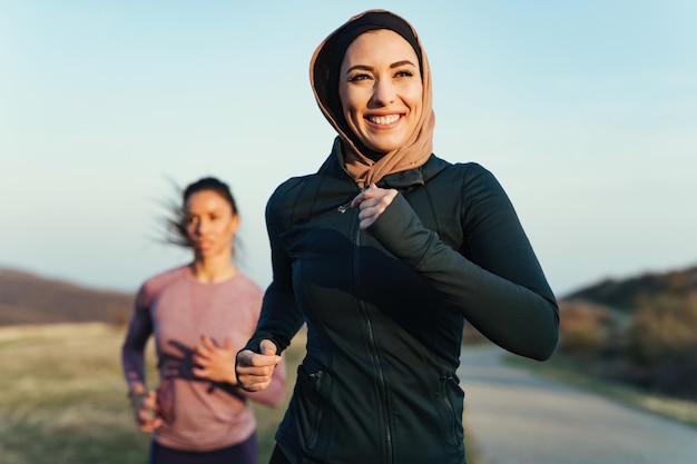 Deportista sonriente disfrutando de trotar por la mañana con su instructor de fitness