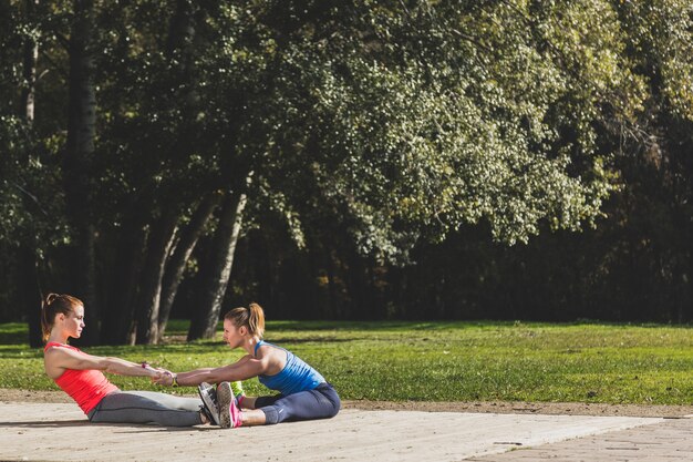 Deportistas estirando juntas al aire libre