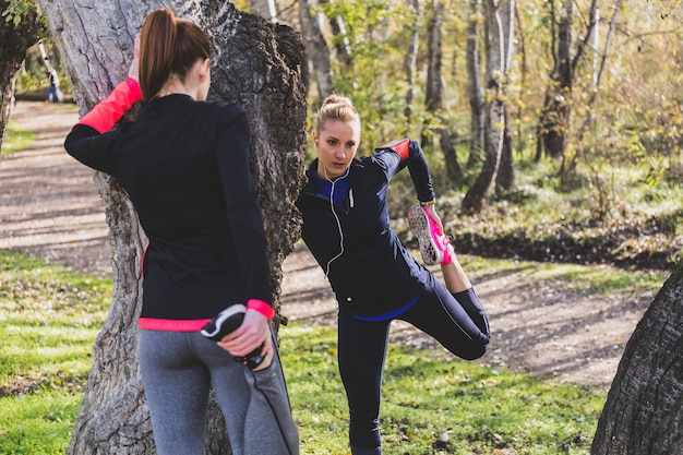 Deportistas estirando piernas al aire libre