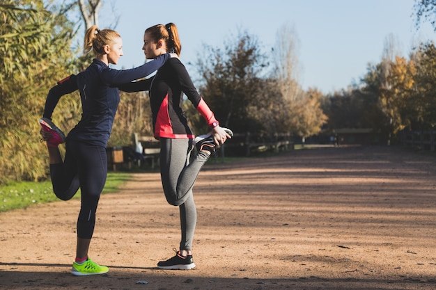 Deportistas estirando sus piernas en el parque