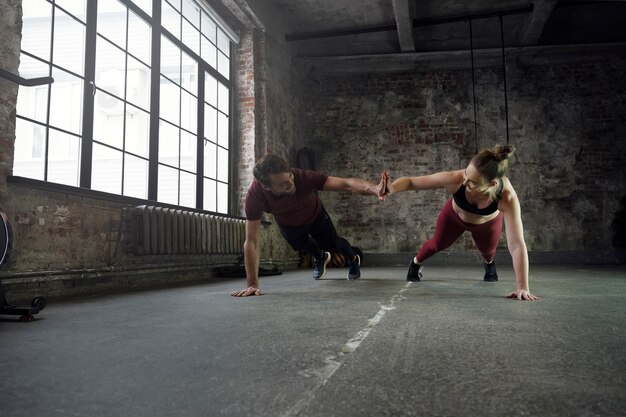 Deportistas en forma de tiro completo haciendo burpees