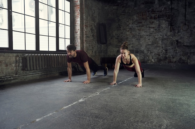 Deportistas de tiro completo haciendo burpees