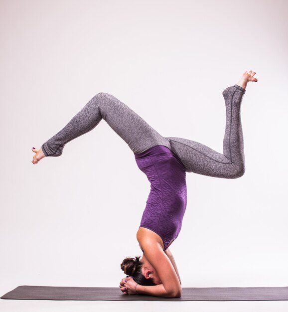 Deportiva joven haciendo práctica de yoga aislada sobre fondo blanco - concepto de vida sana y equilibrio natural entre el cuerpo y el desarrollo mental