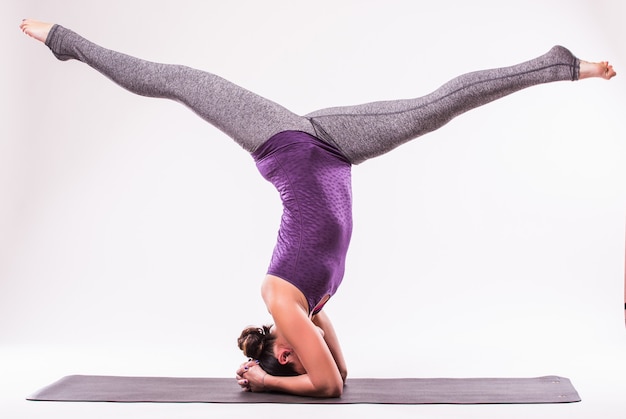 Deportiva joven haciendo práctica de yoga aislada sobre fondo blanco - concepto de vida sana y equilibrio natural entre el cuerpo y el desarrollo mental