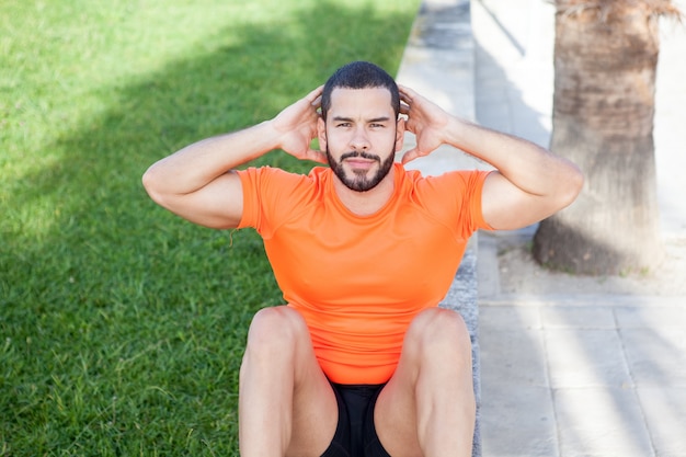 Deportivo brutal joven haciendo abdominales crunches