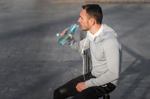 Deportivo joven bebiendo agua