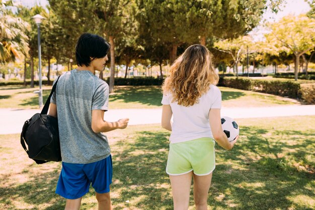 Deportivos amigos adolescentes caminando por el parque