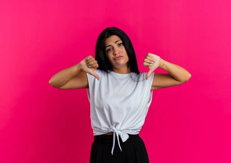 Foto gratuito desagradable joven caucásica pulgares hacia abajo con las dos manos