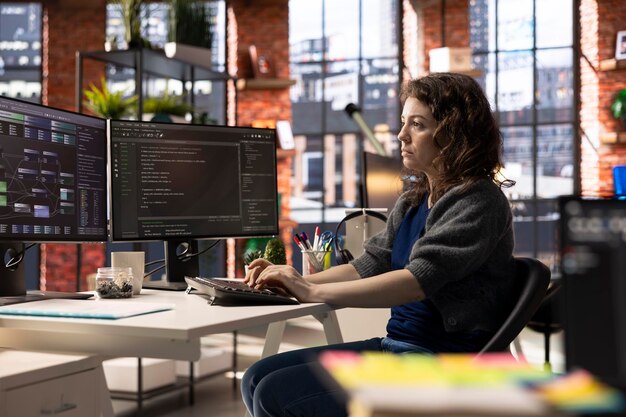 Desarrollador de software en la oficina de la agencia codificando en su computadora creando un software