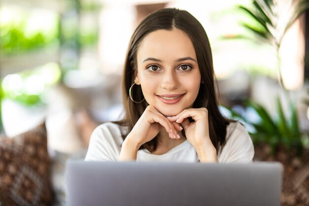 Desarrolladora de front-end profesional que supervisa el rendimiento del sitio web en una computadora portátil mientras trabaja a distancia. Chica estudiante internacional viendo seminario web mientras descansa en una cafetería.