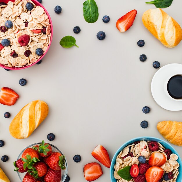 Desayune con el muesli, frutas, bayas, nueces en fondo gris.