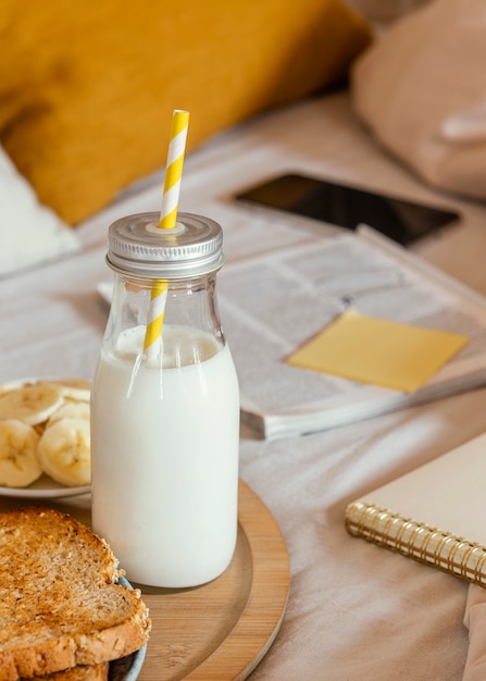 Foto gratuita desayuno de alto ángulo con leche y pan.