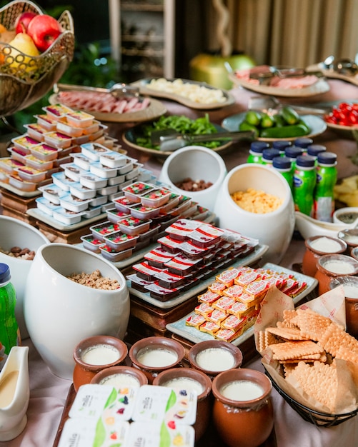 Foto gratuita desayuno buffet con mermeladas de mantequilla, yogures y galletas.