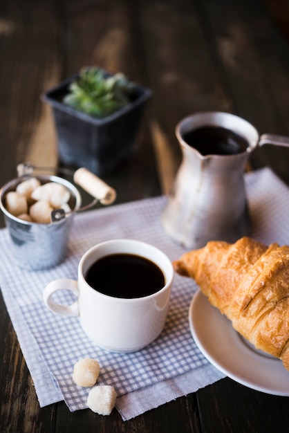 Desayuno de café y croissant por la mañana.