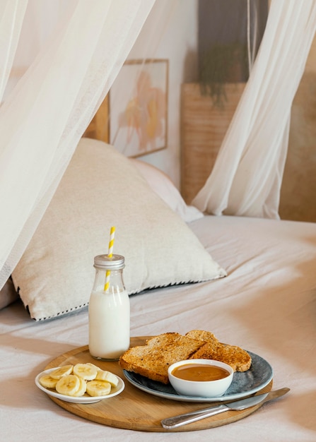 Desayuno en la cama con leche, plátano y pan