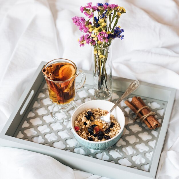 Desayuno en la cama con muesli y té.