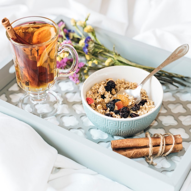 Desayuno en la cama con muesli y té.