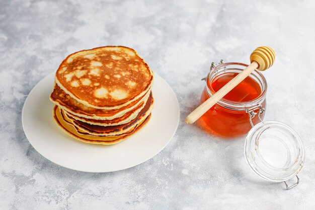 Desayuno casero: tortitas de estilo americano servidas con peras y miel con una taza de té en concreto. Vista superior y copia