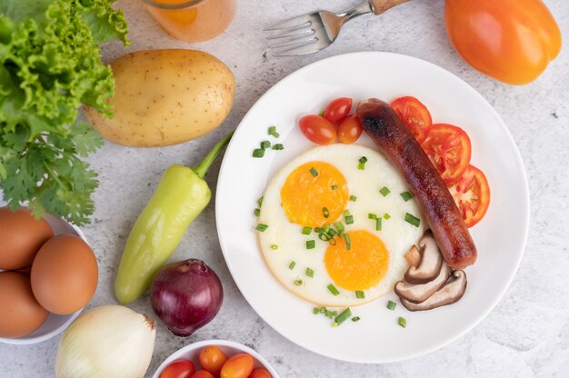 El desayuno consiste en pan, huevos fritos, tomates, salchichas chinas y champiñones.