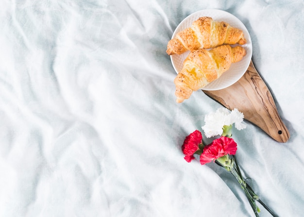 Foto gratuita desayuno con croissant y flores