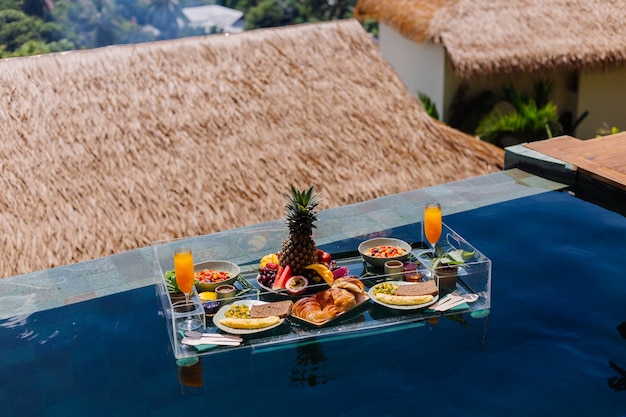 Desayuno flotante en la increíble villa del hotel en la piscina azul