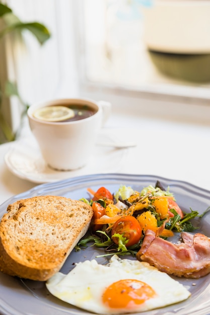 Desayuno fresco saludable con taza de té en mesa blanca