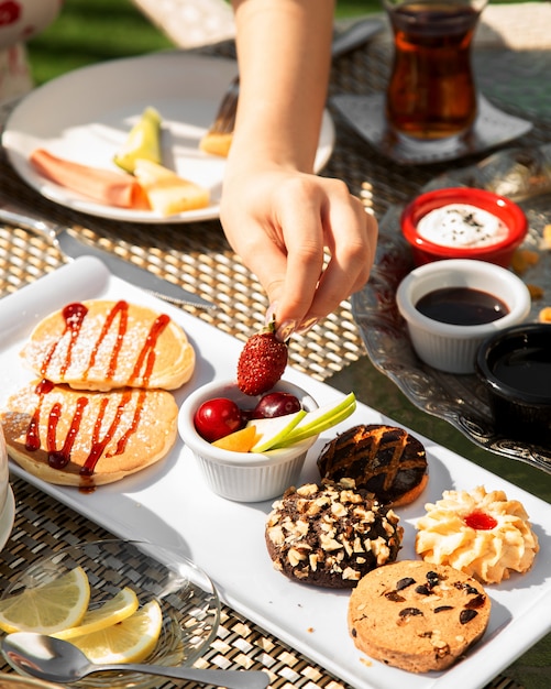 Desayuno con fruta y galletas variadas.