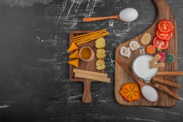 Desayuno con galletas y verduras aislado sobre fondo negro