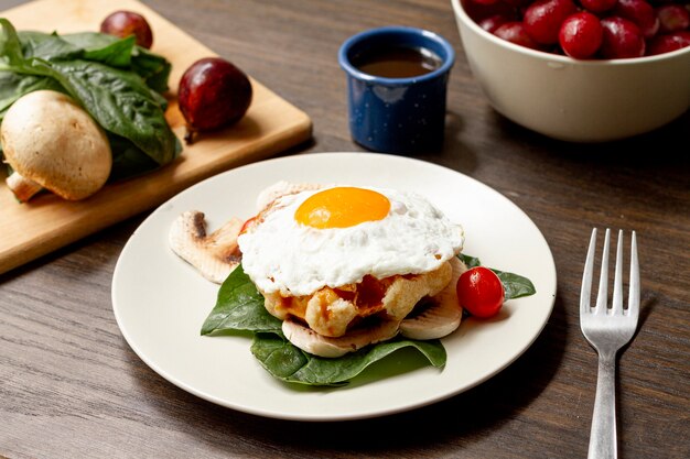 Desayuno de huevo frito con tomate y café.