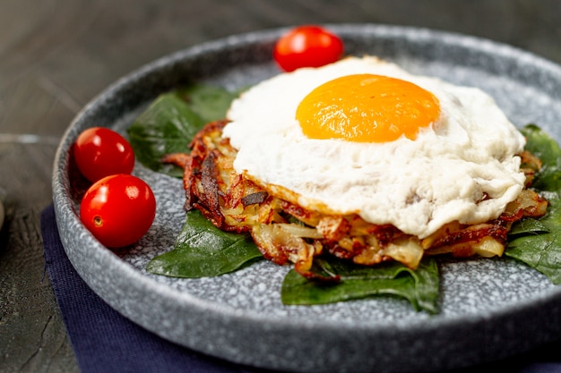 Desayuno de huevo frito con tomate y croquetas de patata